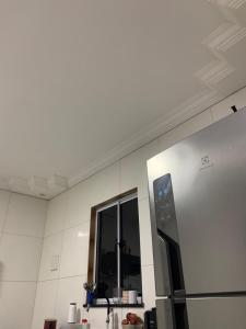 Il comprend une cuisine équipée d'un réfrigérateur et d'une fenêtre. dans l'établissement Casa doss, à Santo Amaro