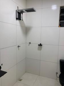une douche blanche avec une porte vitrée dans l'établissement Casa doss, à Santo Amaro