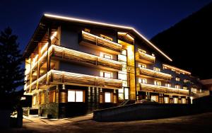 a tall building with lights on it at night at Hotel Garni Angela in Ischgl