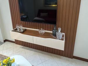 a cabinet with a mirror and some glasses on it at Apartamento Beira Mar Praia da Costa in Vila Velha +27 photos