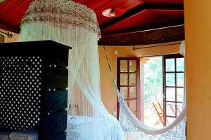 a bedroom with a bed with a mosquito net at Casa Sustentável de Terra! in Lençóis