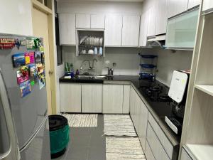 a kitchen with white cabinets and a refrigerator at Maryam Homestay Putrajaya17 in Putrajaya