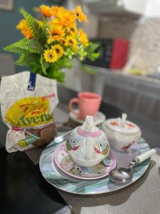 a table with a tea pot and a vase with flowers at Hospedaje Umma-Ezeiza in Ezeiza +17 photos