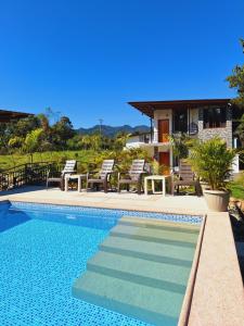 a swimming pool in front of a house at Royal River Suites & Spa Aparthotel in Mindo