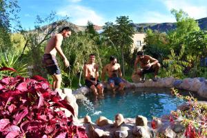 a group of men sitting around a swimming pool at El Huayllar in Cusco