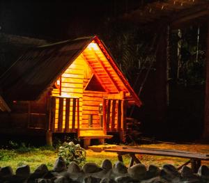 a small wooden house with a bench in front of it at El Huayllar in Cusco +2 photos