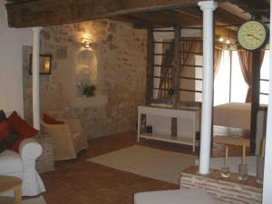 sala de estar con cama y reloj en la pared en Les Terraces Sur La Dordogne, en Sainte-Foy-la-Grande