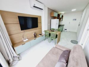 a living room with a flat screen tv on a wall at Ap no Coração de Porto de Galinhas Paulo Brito 101 - By Anfitrião Legal in Porto De Galinhas