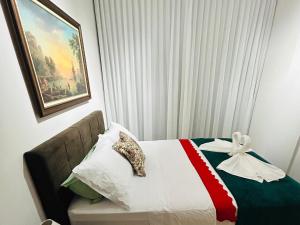 a hotel room with a bed with a bow on it at Apartamento Beira Mar Praia da Costa in Vila Velha
