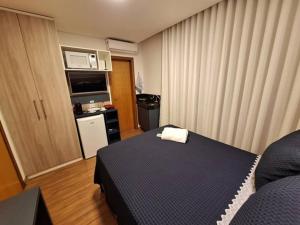 ein Hotelzimmer mit einem Bett und einer Mikrowelle in der Unterkunft Flat de luxo em Lagoa Santa in Lagoa Santa + 7 Fotos