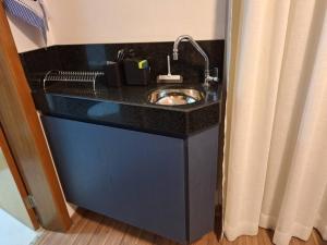 eine Badezimmertheke mit einem Waschbecken in einem Zimmer in der Unterkunft Flat de luxo em Lagoa Santa in Lagoa Santa