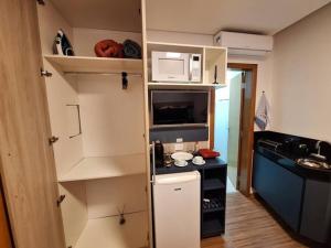 eine kleine Küche mit Theke und Mikrowelle in der Unterkunft Flat de luxo em Lagoa Santa in Lagoa Santa