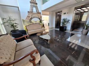 ein Wohnzimmer mit einer Couch und dem Eiffelturm in der Unterkunft Flat de luxo em Lagoa Santa in Lagoa Santa