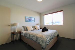 a bedroom with a bed with a teddy bear on it at Simply The Best, Couple Getaway in Huskisson in Huskisson