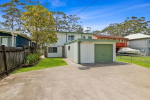 une maison avec un garage et une clôture dans l'établissement On Collingwood Beach - Upstairs Apartment, à Vincentia 6 autres photos
