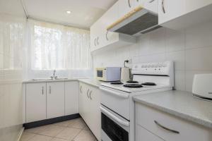 ビンセンチアにあるOn Collingwood Beach - Downstairs Apartment - 50m from the beachのコンロとシンクのある白いキッチン +7枚の写真