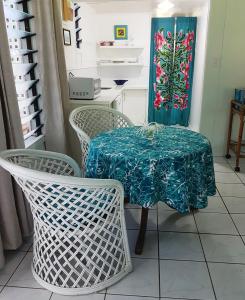 a table with two chairs and a table with a table cloth at Vaka Beach Cottage with AC Unlimited Wifi in Rarotonga