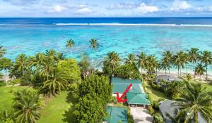 an aerial view of a resort with palm trees and the ocean at Vaka Beach Cottage with AC Unlimited Wifi in Rarotonga