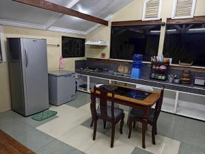 a kitchen with a table and a refrigerator at Davao City-Marilog Peak Cafe- Traveler's Staycation in Davao City