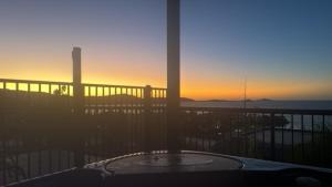 a hot tub on a balcony with the sunset in the background at Holiday on The Horizon Airlie Beach Holiday Home in Airlie Beach +15 photos