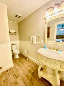 Un baño con lavabo, inodoro y espejo. en Oak Cottages 3, en Rockport
