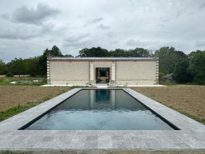 basen z wodą przed budynkiem w obiekcie Gîte de charme avec piscine chauffée et sauna, au cœur d'une propriété historique en Val de Loire - FR-1-381-128 w mieście Monnaie