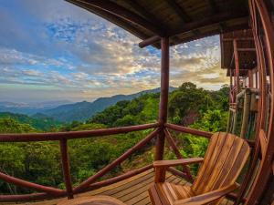 a chair on a porch with a view of the mountains at Loma Nevada Minca Hotel in Minca