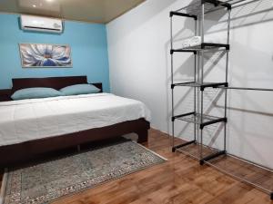 a bedroom with a bed and a blue wall at La Fortuna Living - Room in Fortuna