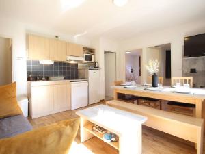 uma cozinha e uma sala de estar com uma mesa e uma cozinha e uma sala de estar em Appartement T3 à Luchon: Balcon, Parking, Proche Thermes & Centre, Bien Équipé - FR-1-313-232 em Luchon