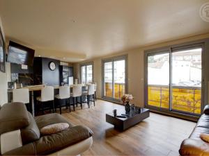 salon z kanapą i stołem oraz kuchnia w obiekcie Appartement lumineux avec balcon, 2 chambres, parking privé, proche gare à Saint-Chamond - FR-1-496-272 w mieście Saint-Chamond