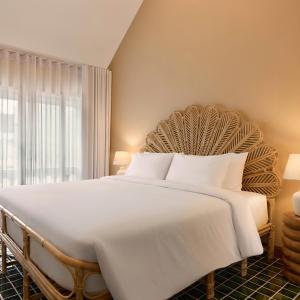 a large white bed in a room with a window at Dolly Beach House by Yudee Assets in Hua Hin