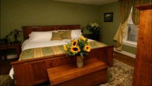 a bedroom with a bed with a vase of flowers on it at Bayside Inn in Parry Sound