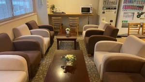 ein Wartezimmer mit Sofas und einem Tisch mit Blumen in der Unterkunft Hakodate Hotel Ekimae - Vacation STAY 91716v in Hakodate