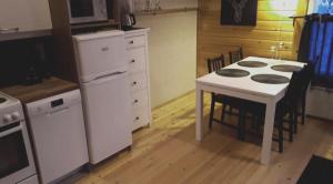 cocina con mesa, mesa blanca y sillas en Cosy Holiday Cabin in the Heart of Lapland, en Ylläs 4 fotos más