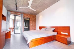 a bedroom with a bed and a brick wall at CRIN HOUSE Đồng Châu in Lạc Thành