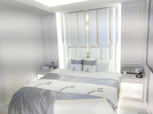 Dos camas en una habitación con paredes blancas. en HOTEL The GRAF Matsubara, en Miyake 2 fotos más