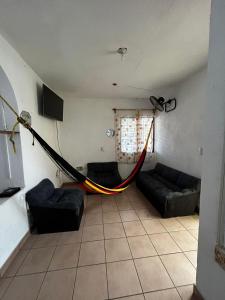 een woonkamer met een bank en een televisie bij Casa Flor de Mayo in Santa Cruz Huatulco