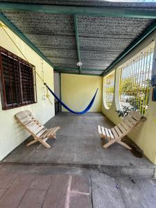 twee banken naast een gebouw met een blauwe slang bij Casa Flor de Mayo in Santa Cruz Huatulco