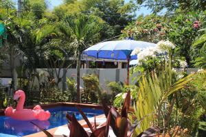 a swimming pool with a pink flamingo in a garden at New Balengku Dua Hotel in Gili Air