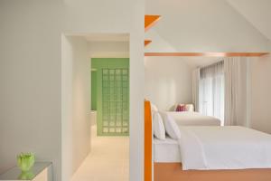 a hotel room with two beds and a bathroom at Molly Beach House by Yudee Assets in Hua Hin