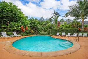 Una gran piscina con sillas y árboles. en Kapaa Sands 19, en Kapaa