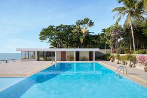 a swimming pool in front of a house at Molly Beach House by Yudee Assets in Hua Hin