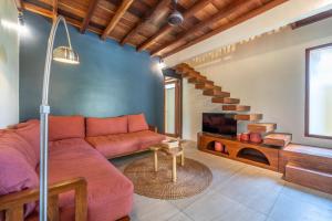 Una sala de estar con un sofá y una escalera. en La Villa Loca, en Gili Air