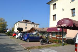 un parcheggio con una moto parcheggiata accanto a un edificio di Tricolore Hotel a Gaida