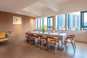 重庆Wuyu Hotel - Chongqing Jiangbei Airport & Light Rail的一张大桌子,房间设有大窗户