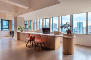 重庆Wuyu Hotel - Chongqing Jiangbei Airport & Light Rail的办公室设有一张带椅子和窗户的大桌子
