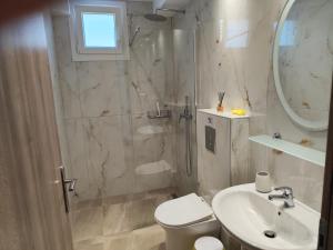 a bathroom with a shower and a toilet and a sink at Ariadne's garden in Astris +14 photos