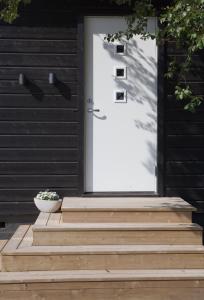 a front door of a house with a plant on the steps at Tana Panorama Apartments in Skiippagurra