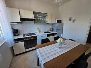 eine Küche mit einem Tisch und eine Küche mit weißen Geräten in der Unterkunft Gianna Apartment Labin in Labin