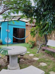 a table and bench in a yard with a house at SJO Green Casita in Santiago Este